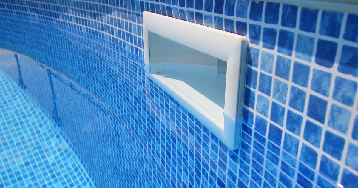 Drain hole in the pool with blue tile.