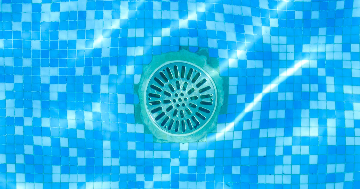 Drain of a pool, seen through the water from above.